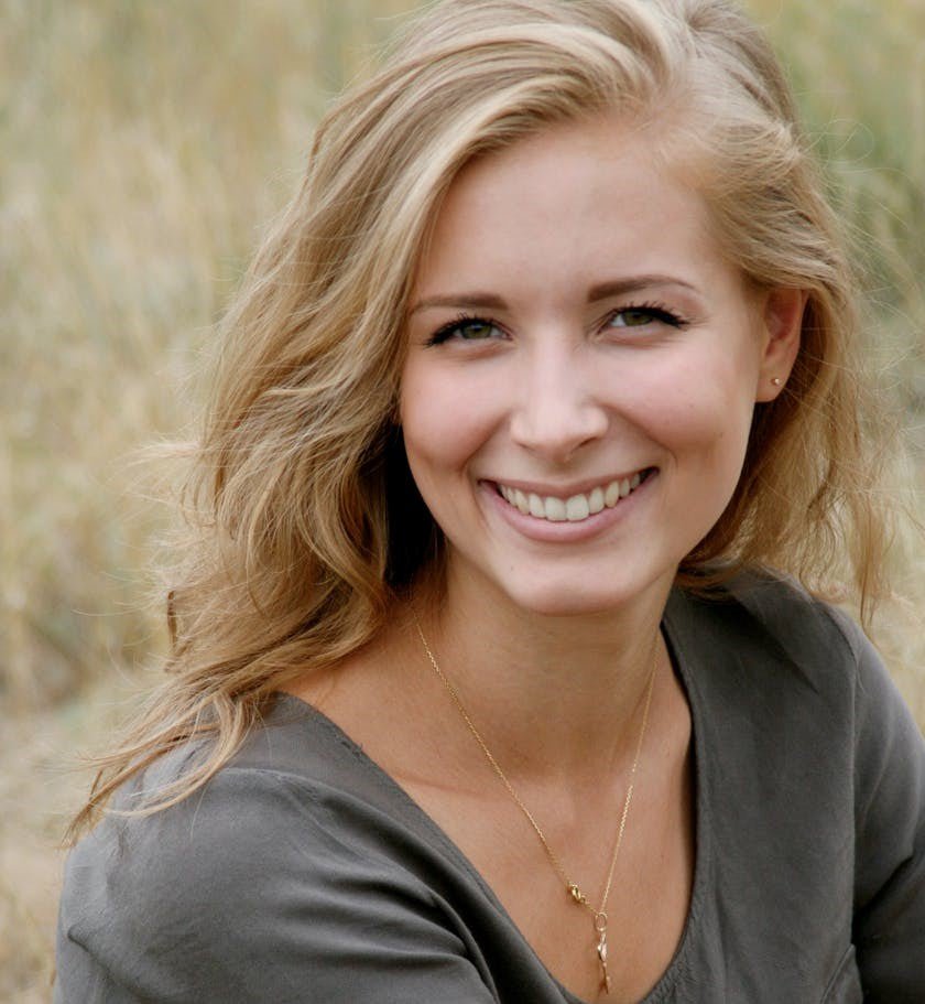 living room with rattan loveseat styled with plants and accent pillows - indoor rattan loveseat
