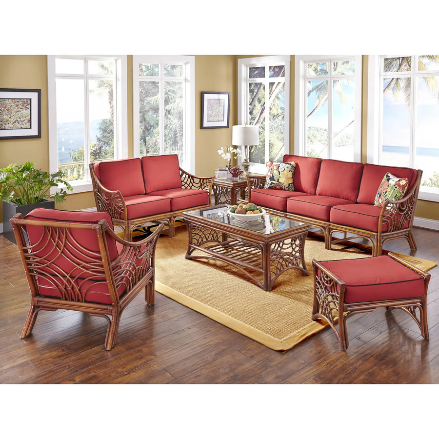 Brownwash Bali ottoman with a red cushion near the matching sofa, loveseat and arm chair in a sunroom
