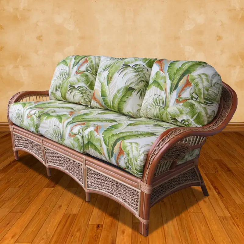 Islander sofa, loveseat, arm chair, ottoman and wicker tables in Natural with black leaf cushions in a sunroom by the beach