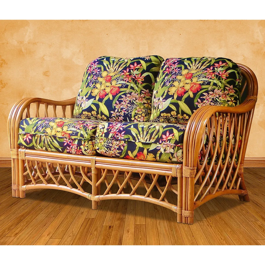 Montego Bay loveseat in cinnamon rattan with black orchid print seat and back cushions, tan wall and wood floor
