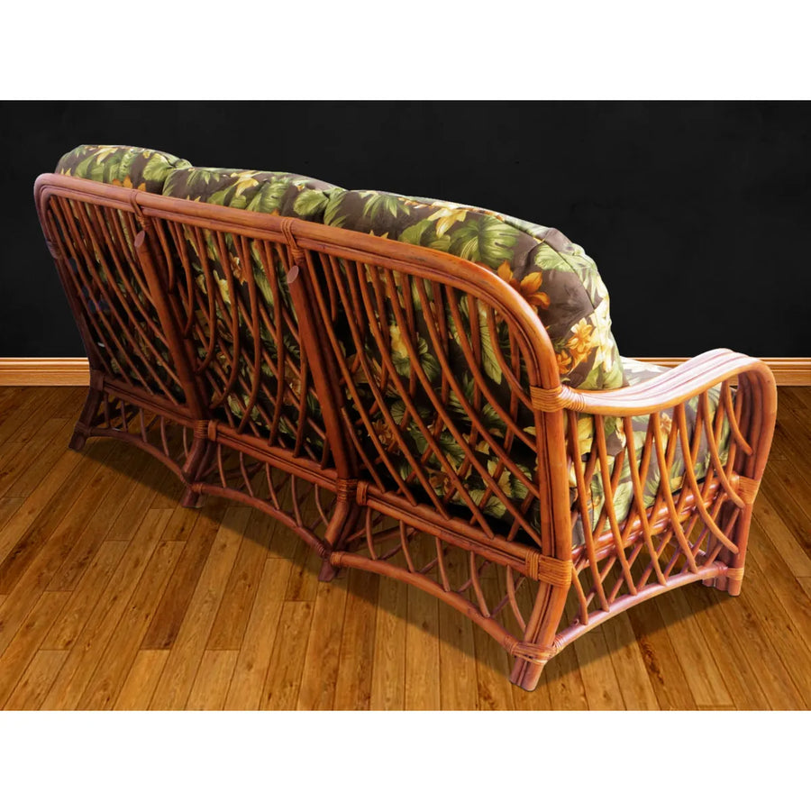 Back of the Montego Bay sofa in cinnamon rattan, three open lattice panels with dark green floral cushions