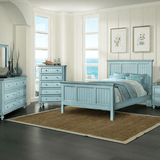 Blue king bedroom set from the Monaco collection in a bright room with the bed, dresser and mirror, tall chest and nightstand