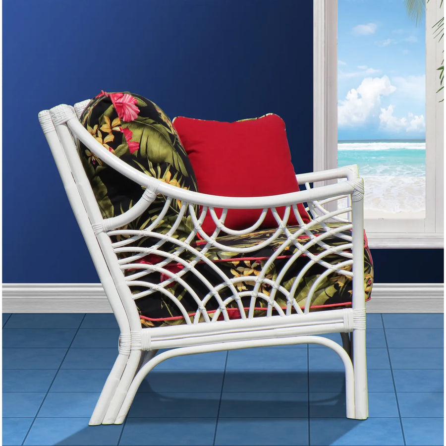 Side view of the Bali arm chair in White, showing the outward curving arm and rattan arcs, with a black floral cushion and red pillow