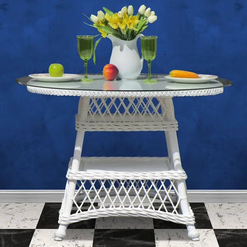 Round wicker dining table in white with a glass top, diamond lattice band and woven lower shelf, front view
