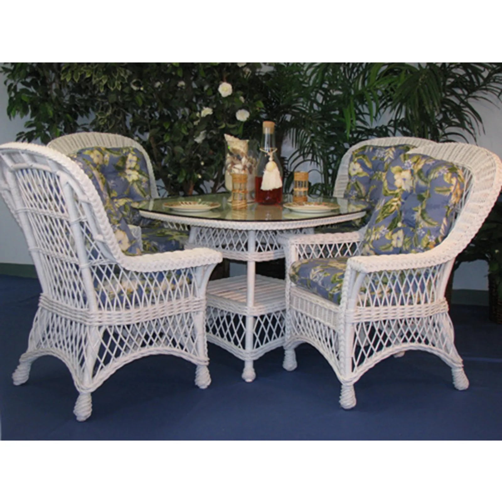 Bar Harbor white wicker dining set with a round glass table and four dining arm chairs with blue floral cushions