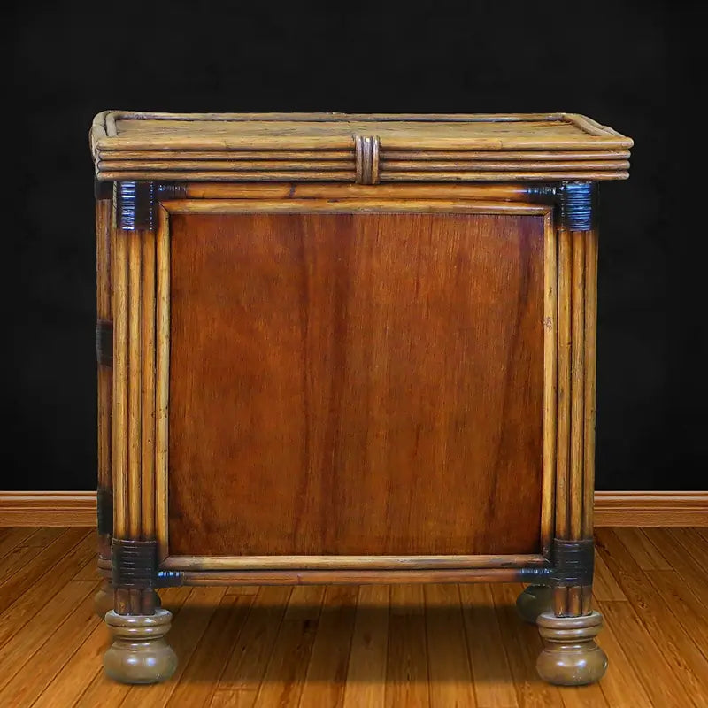 Back of the antique brownwash night stand, showing a wood-grain back panel framed by poles
