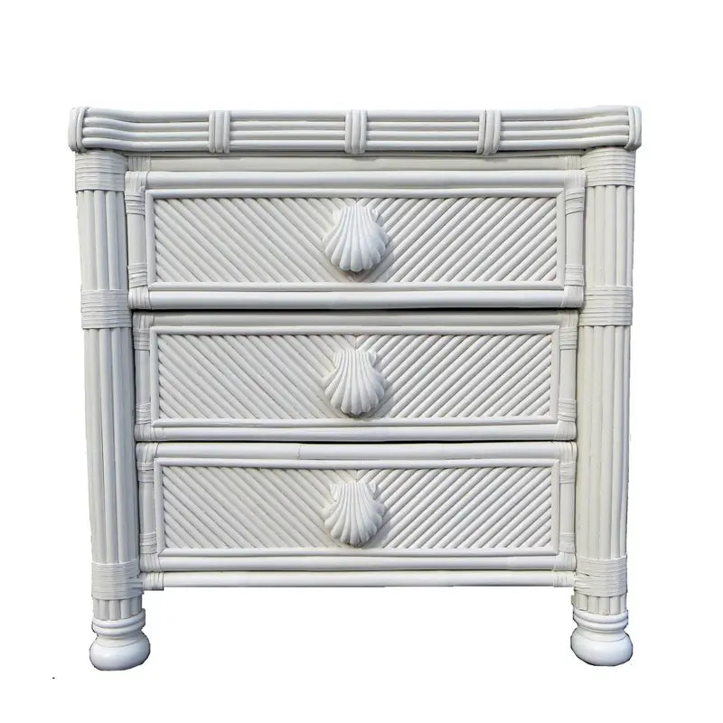 Small white rattan dresser, front view, with diagonal-woven drawer fronts, seashell pulls and round bun feet