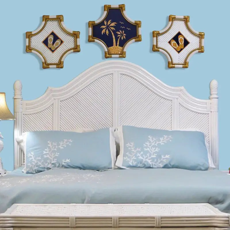 White wicker headboard with an arched top, pineapple finials and four diagonal-woven panels on a blue wall