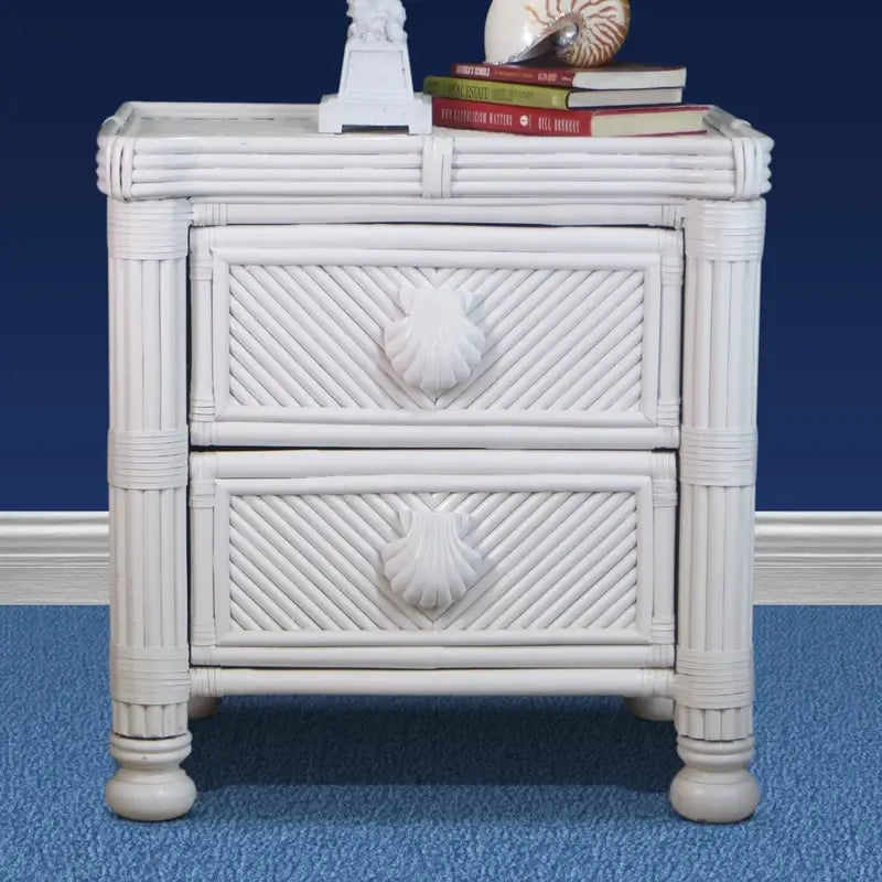 White wicker nightstand, front view, with two diagonal-woven drawers, seashell pulls and round bun feet