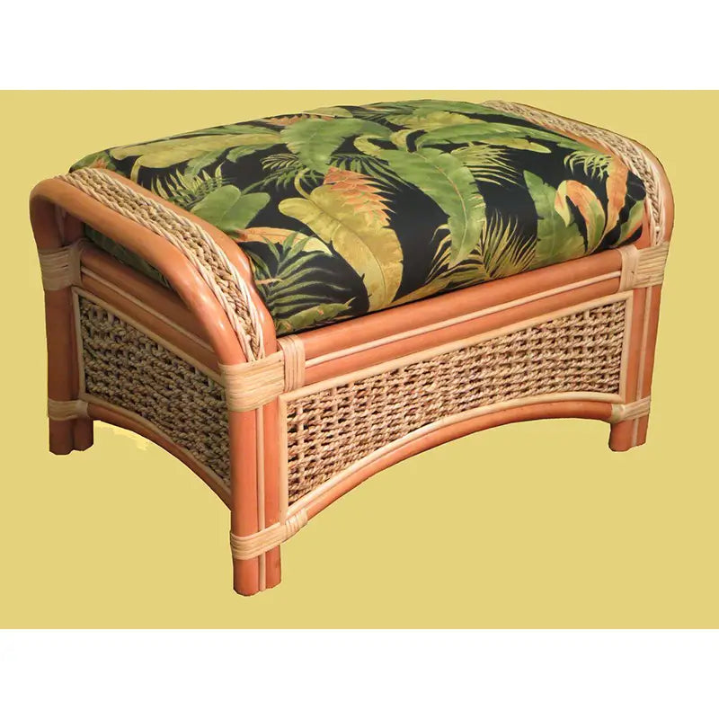 Islander ottoman in Natural, angled, with a black palm leaf cushion, woven side panels and rattan arms curved over the ends