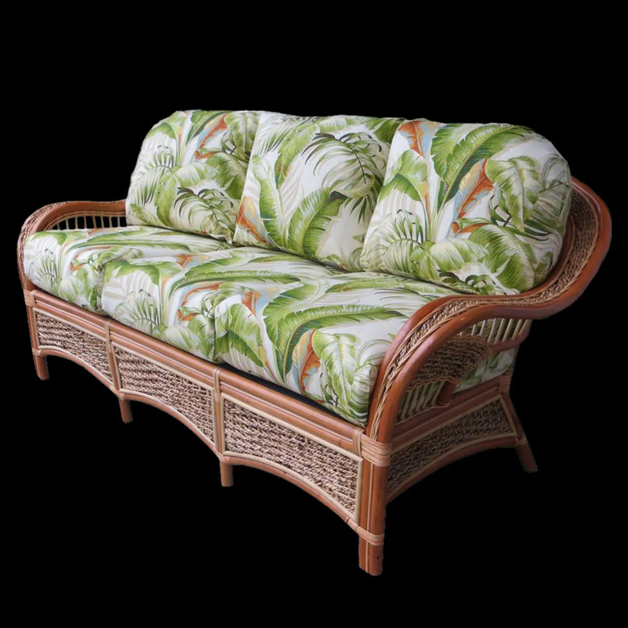 Islander sofa in Natural with palm leaf cushions on a black background