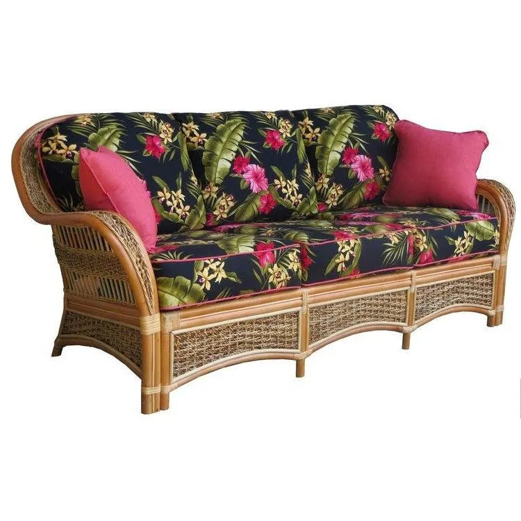 Islander tropical couch in Natural with green and white palm leaf cushions, against a tan wall