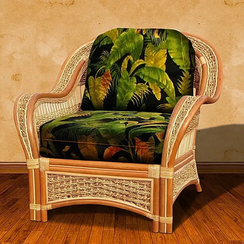 Front view of the Islander wicker accent chair in Natural with black and green tropical leaf seat and back cushions
