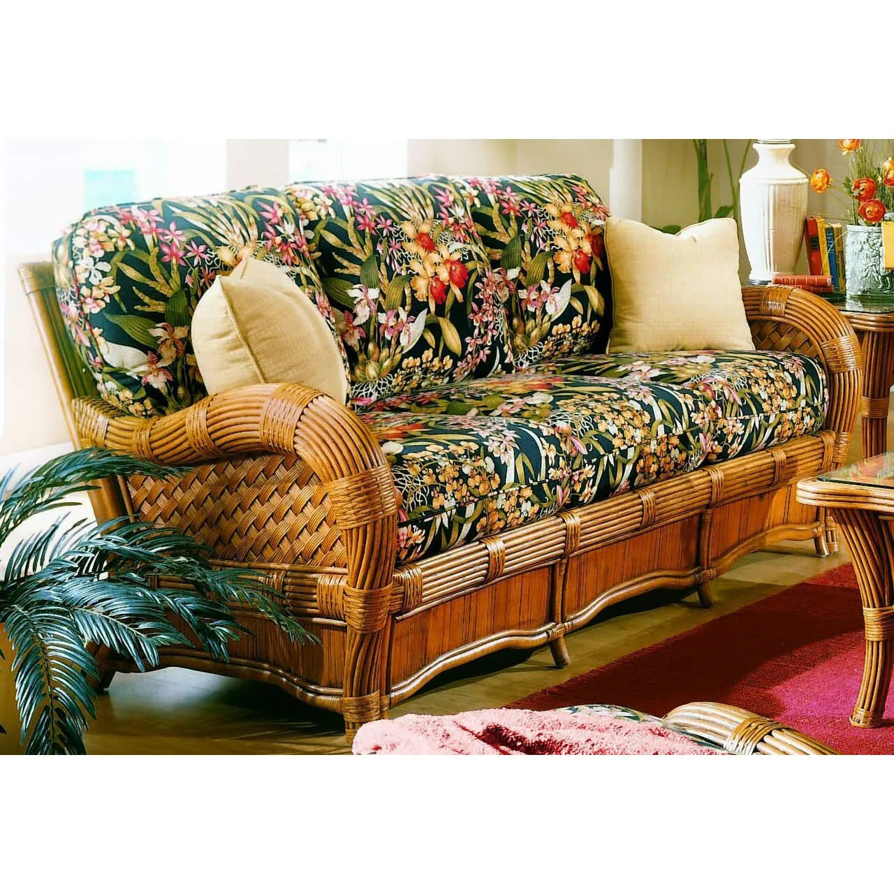 Cinnamon wicker couches: the Kingston Reef sofa with black tropical floral cushions and cream throw pillows