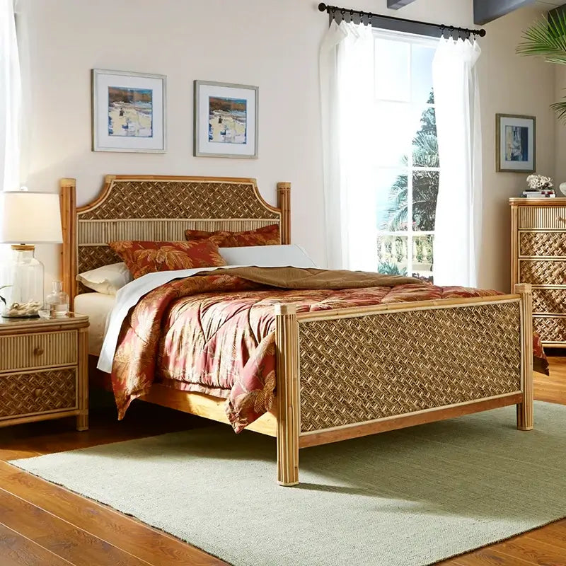 Bed from the Mandalay king bedroom set with basket-weave rope panels, bundled rattan posts and red palm-print bedding