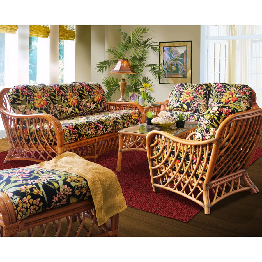 Montego Bay loveseat at the back of a sunroom with the matching sofa, arm chair, ottoman and glass coffee table in cinnamon rattan
