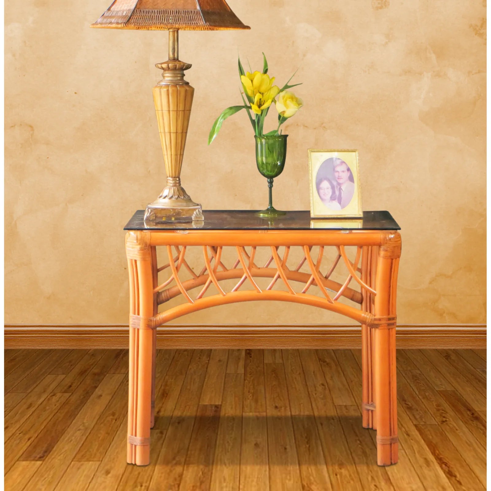 Montego Bay rattan end table with glass top in Cinnamon, with a lamp and flowers on top