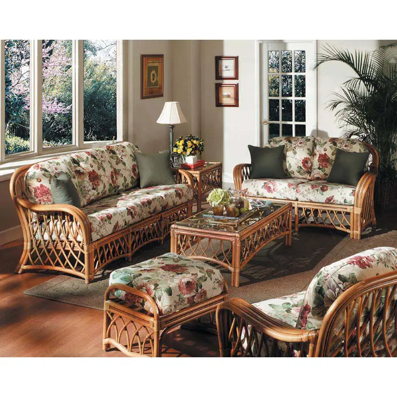 Montego Bay rattan living room set in a sunroom, with rose print cushions, green pillows, coffee table and end table