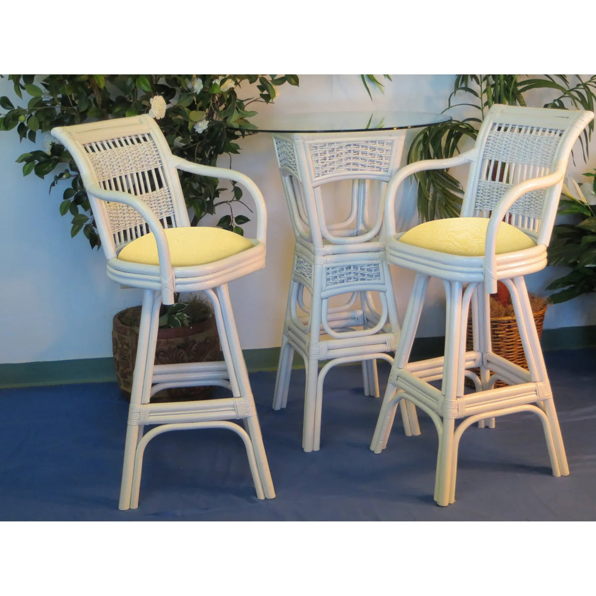 Two white rattan bar stools from the Regatta collection with yellow seat cushions at the matching bistro table