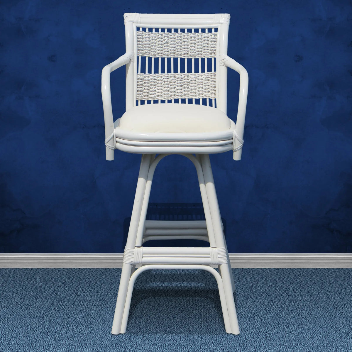Regatta white wicker bar stool with arms, a woven back panel and a white seat cushion