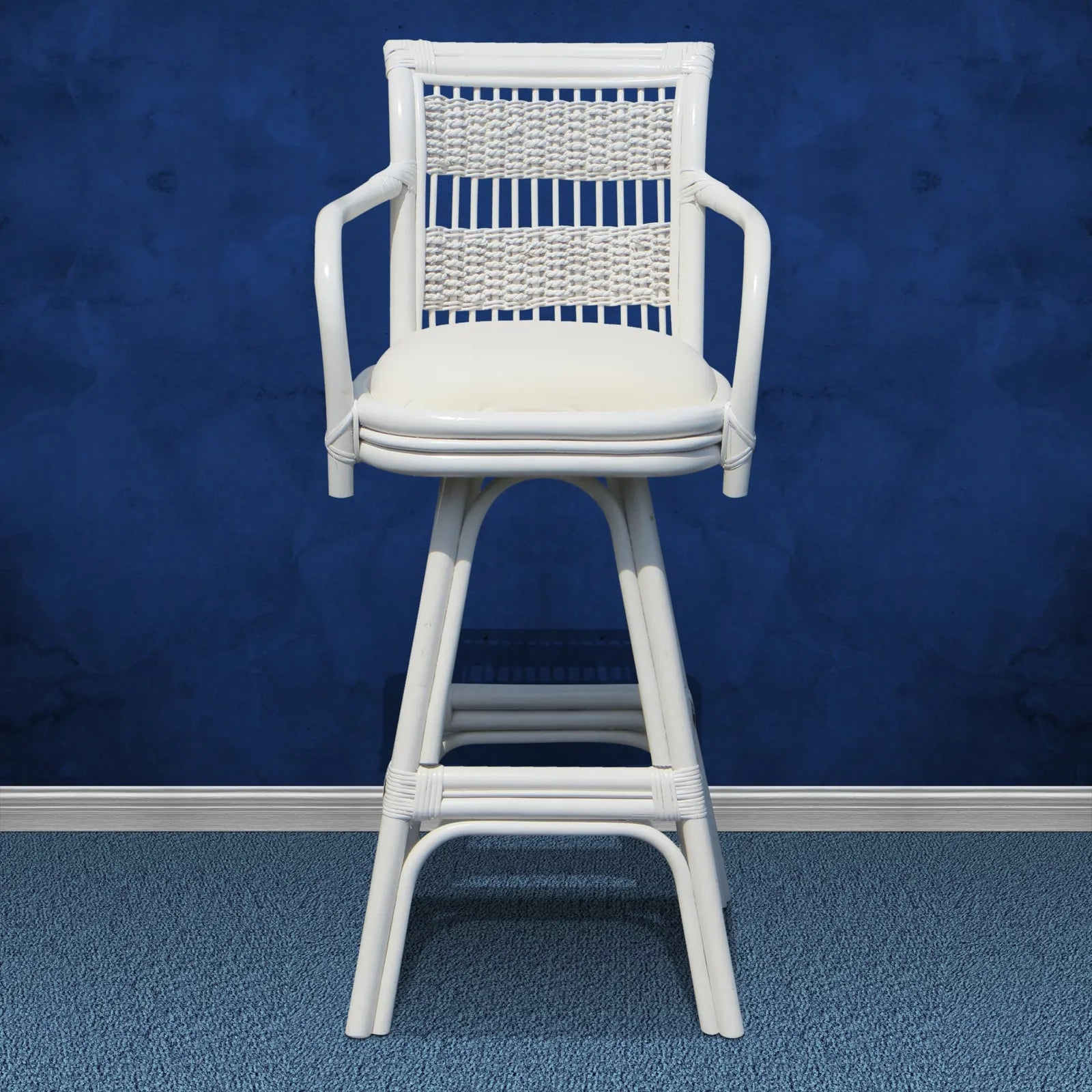 Regatta white wicker bar stool with arms, a woven back panel and a white seat cushion