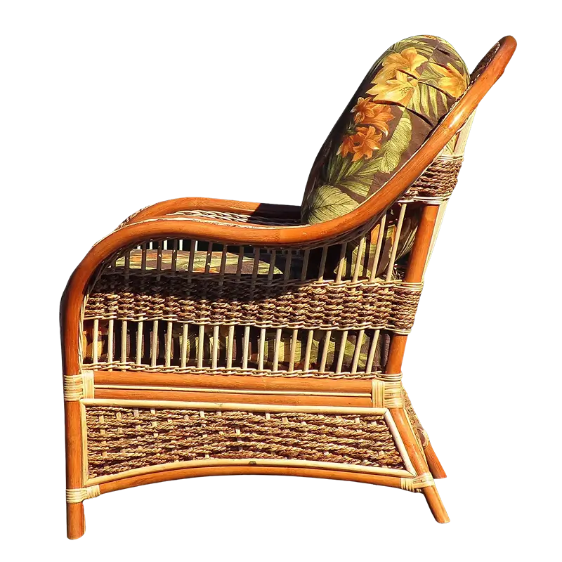 Side profile of the Spice Islands Wicker Spice Island Armchair Natural, showing the curved rattan frame and banana bark rope weave with a tropical floral back cushion