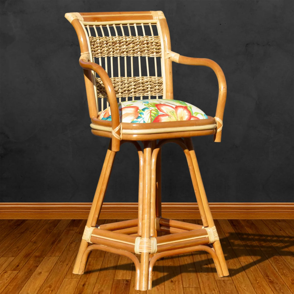Natural rattan bar stool from the Spice Island collection with arms, a woven back and a tropical print seat cushion