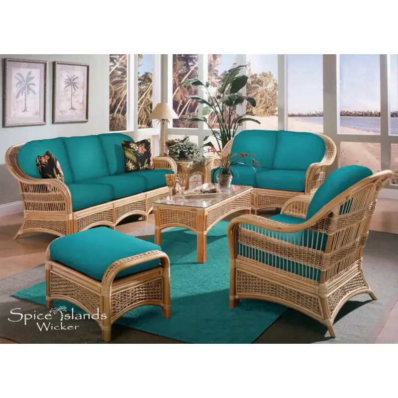Spice Island wide arm sofa in natural rattan, three-quarter view, with black hibiscus print cushions and woven base panels