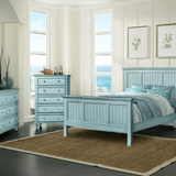 Monaco bedroom set in Bleu in a bright room with ocean windows: the bed, dresser with mirror, tall chest and nightstand