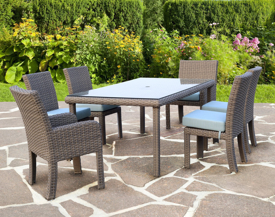 Stone St. Tropez dining set with sky blue cushions on a flagstone terrace with flowers