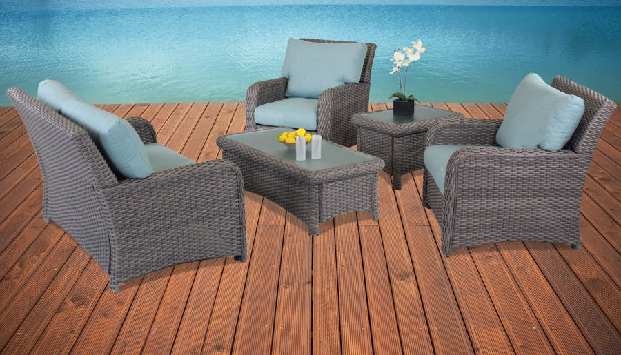 Stone St. Tropez lounge chairs with light blue cushions, the coffee table and end table on a waterside deck