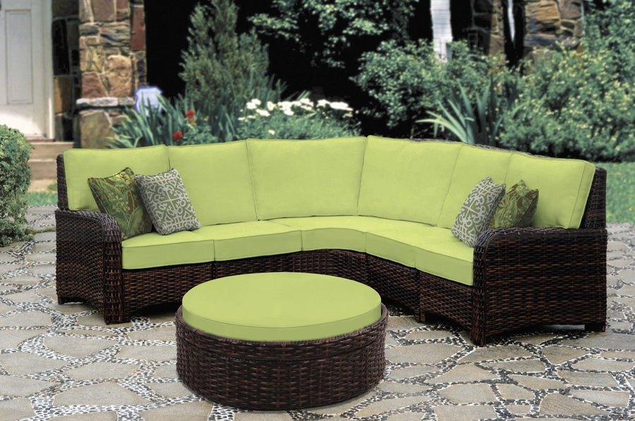 Tobacco St. Tropez curved sectional with lime green cushions and a round ottoman on a garden patio