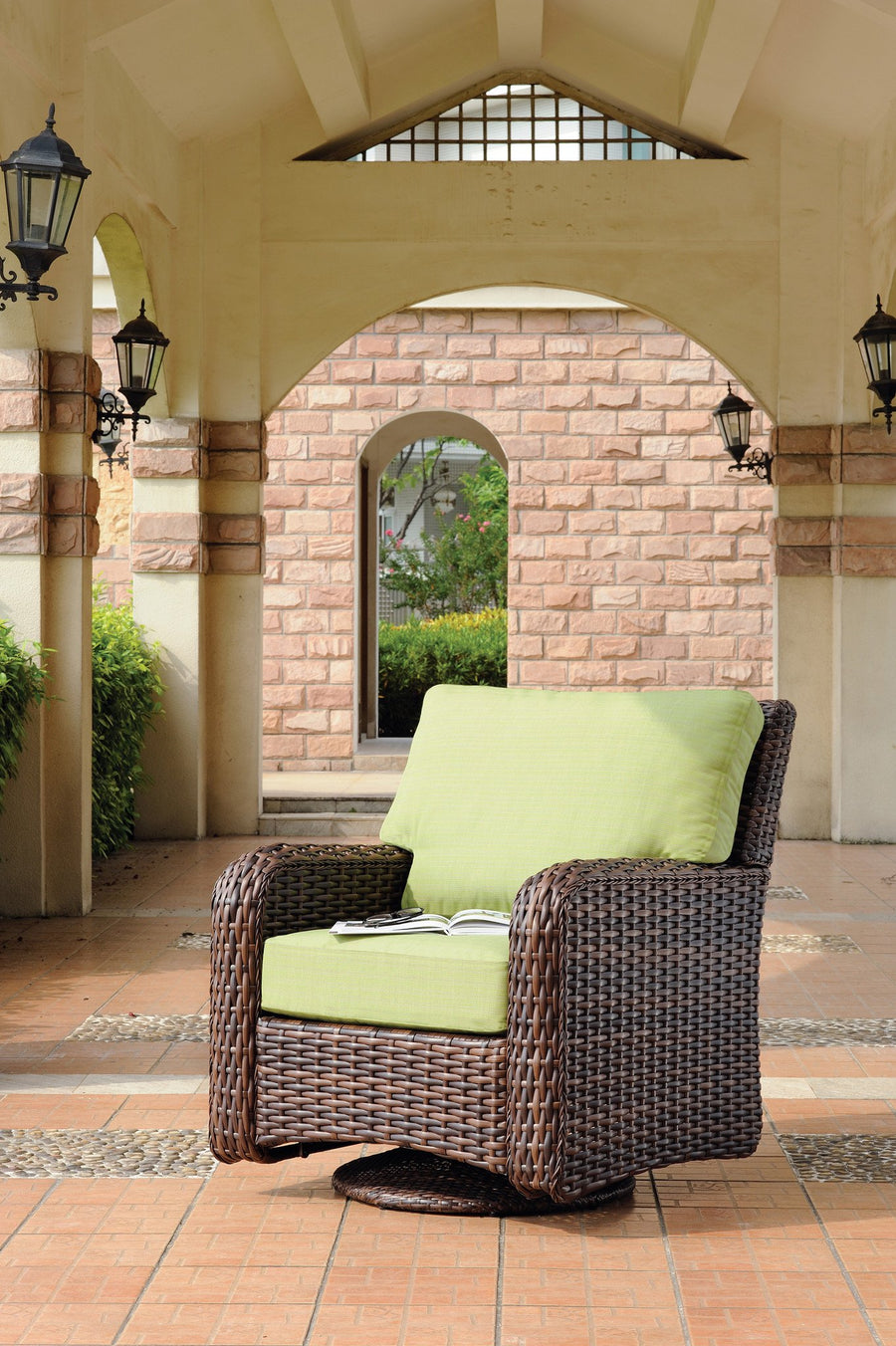 Tobacco St. Tropez swivel glider with lime green cushions under a stone archway
