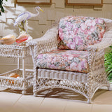 Bar Harbor arm chair with pink floral cushions beside a matching end table topped with a heron figurine and conch shells