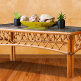 Montego Bay shell coffee table shown in the natural finish, with a bowl of seashells and two plants on the glass top