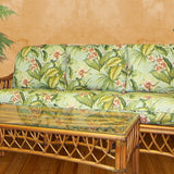 Montego Bay cinnamon sofa with light green tropical leaf cushions, shown behind the matching coffee table