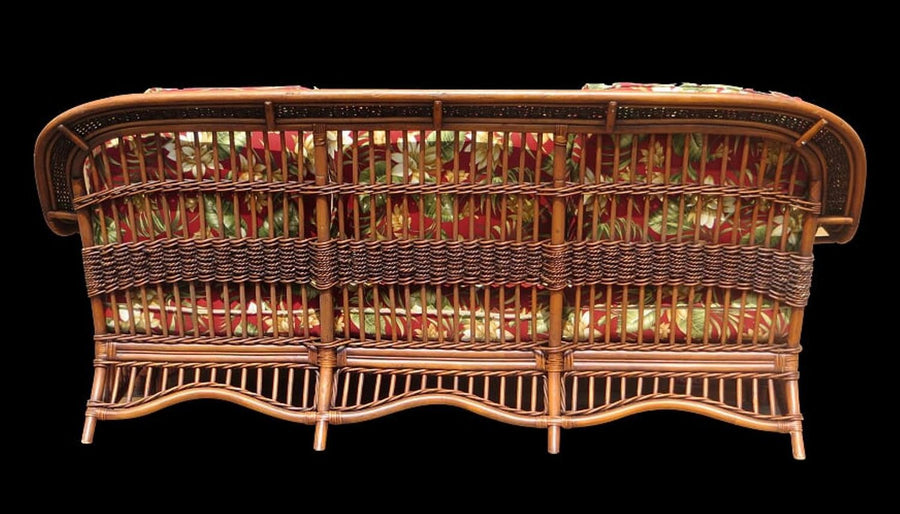 Rear view of the brownwash Seascape sofa with red floral cushions showing through the spindles
